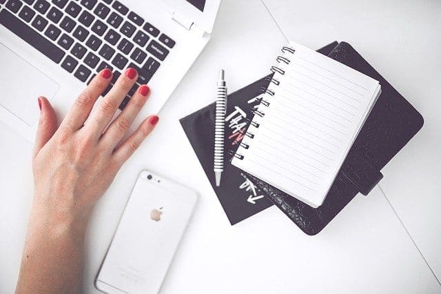 The hand of a woman blogger with red nail polish